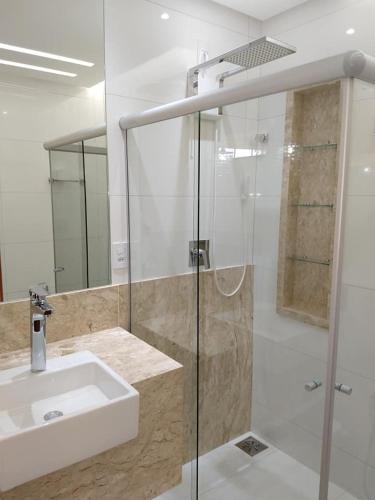 a bathroom with a glass shower and a sink at Hotel Panorâmico in Carmo do Paranaíba