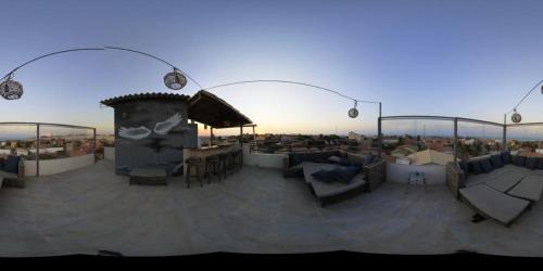 a rooftop patio with couches and tables and lights at Pousada Villa Calango in Canoa Quebrada