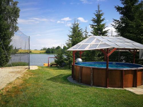 a gazebo with a pool in the grass at Sodyba Brazylija in Taraldžiai