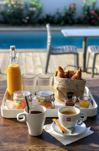a tray with bread and coffee and a basket of orange juice at Villa Jwi Lavi Boutique Hotel in Cul de Sac