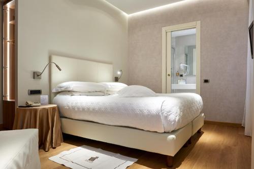 a bedroom with a large bed with white sheets and pillows at Doria Park Hotel in Lerici