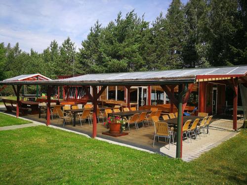a pavilion with tables and chairs in a park at Sodyba Brazylija in Taraldžiai