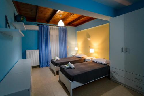 um quarto com 2 camas e paredes azuis em Teo Vivi Maizonette em Zakynthos