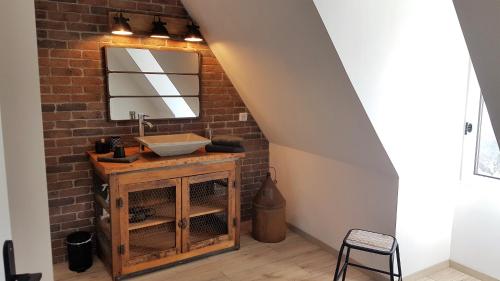 a bathroom with a sink and a brick wall at le clos des etoiles B&B in Le Bugue