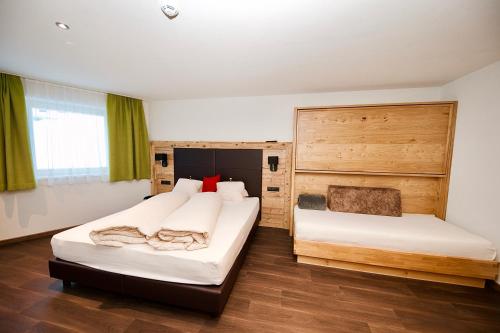 2 Betten in einem Zimmer mit grünen Vorhängen in der Unterkunft Haus Alpenblick in Ladis