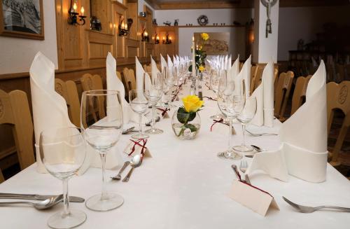 una mesa larga con copas de vino y flores. en Hotel Goldener Stern, en Frauenstein