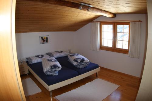 a bedroom with a bed with two pillows on it at Ferienwohnung Rigoleth in Disentis