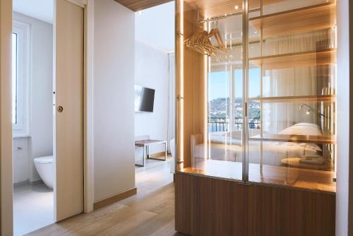 a bathroom with a glass door leading to a bedroom at Doria Park Hotel in Lerici