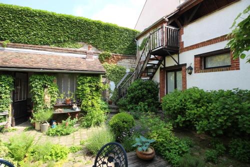 a garden in front of a house with ivy at Jardin de Mathilde in Nangis