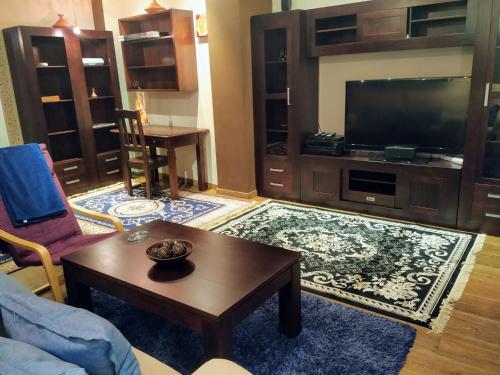 a living room with a television and a coffee table at -1-Igual que tu casa, garaje gratis, en el centro in Úbeda