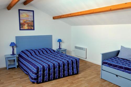 a bedroom with a bed and two tables with lamps at Vacancéole - Les Jardins de l'Amirauté in Les Sables-dʼOlonne