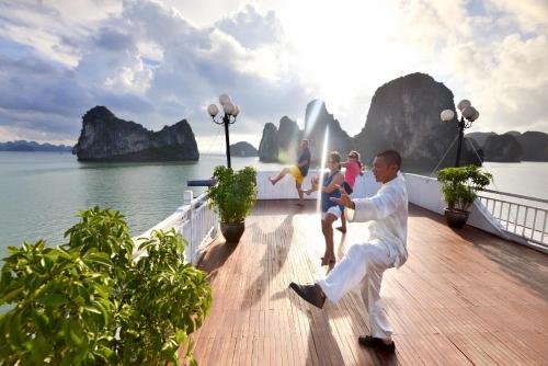 a man is dancing on a boat in the water at Signature Halong Cruise in Ha Long
