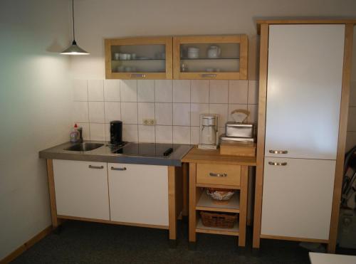 a small kitchen with a sink and a counter at Pension Am Thieberg in Landolfshausen