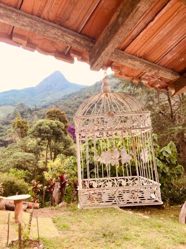 a white bird cage hanging from a roof at Pousada Quinta das Nascentes in Petrópolis