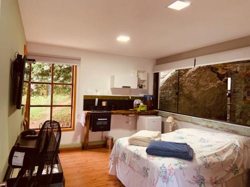 a kitchen with a bed in a room at Pousada Quinta das Nascentes in Petrópolis