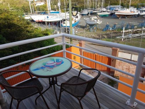 a table and two chairs on a balcony with a marina at Cool Running Apartments in Saint Georgeʼs