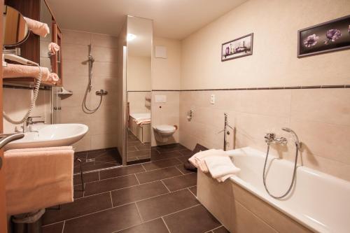 ein Badezimmer mit einer Badewanne, einem Waschbecken und einem WC in der Unterkunft FW Loreleyblick in Sankt Goar