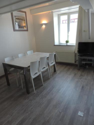uma sala de jantar com uma mesa e cadeiras e uma televisão em Le Metz, Duplex, 2 Chambres em Le Touquet-Paris-Plage