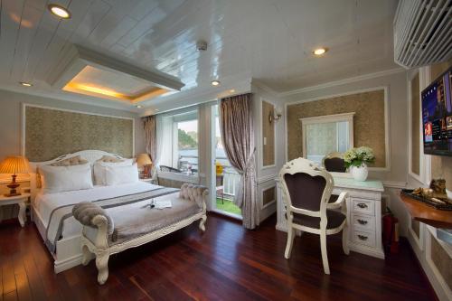 a bedroom with a bed and a desk and chairs at Signature Halong Cruise in Ha Long