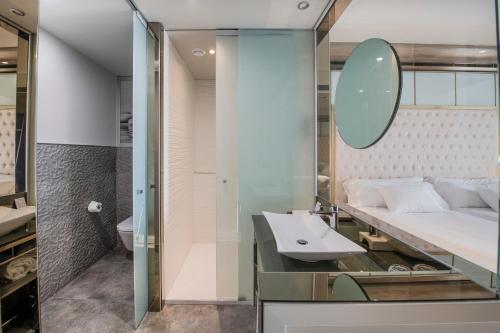 a bathroom with a sink and a bed and a mirror at Barceló Ourense in Ourense