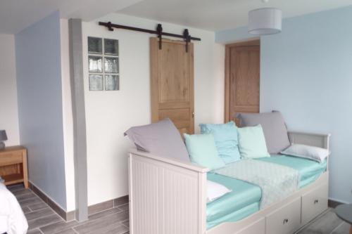 une chambre avec un lit avec des oreillers bleus dans l'établissement Au Rêve en Somme, à Hautvillers-Ouville