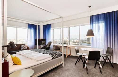 1 dormitorio con 1 cama, mesa y sillas en Comwell Aarhus Dolce by Wyndham en Aarhus