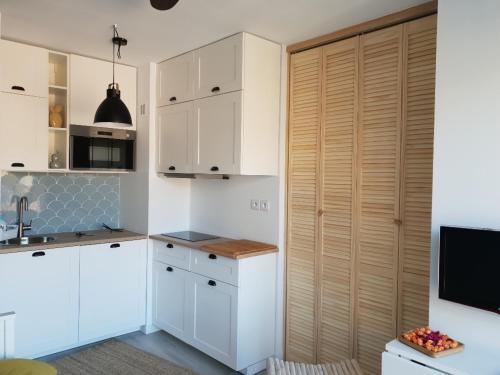 une cuisine avec des placards blancs et un grand placard dans l'établissement Entre terre et mer Plein centre Terrasse, à Cassis