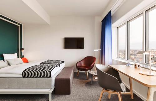 a hotel room with a bed and a desk at Comwell Aarhus Dolce by Wyndham in Aarhus