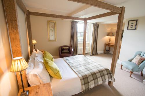 a bedroom with a large bed and a blue chair at The Punch Bowl Inn in Kendal