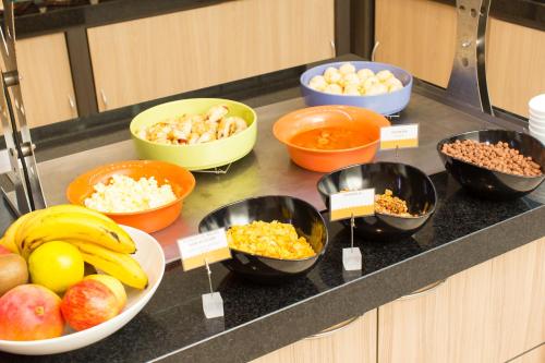a counter with bowls of food on a counter top at Rio Hotel by Bourbon Curitiba in Curitiba