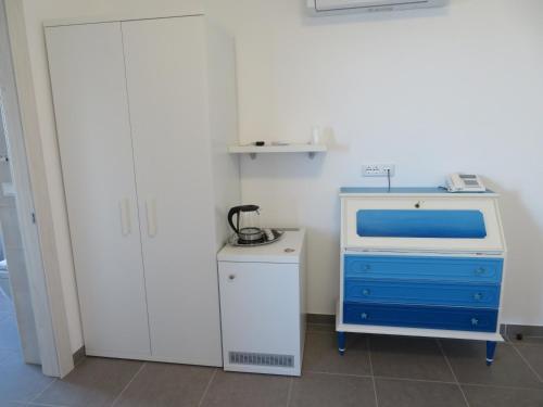 a room with a blue dresser and white cabinets at Il Capanno in Pietra Ligure