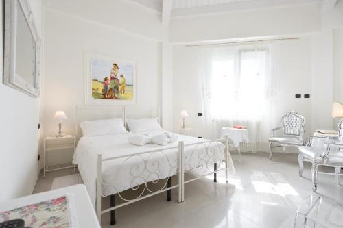 サン・ジョヴァンニ・イン・ペルシチェートにあるHotel San Giovanniの白いベッドルーム(白いベッド1台、椅子付)