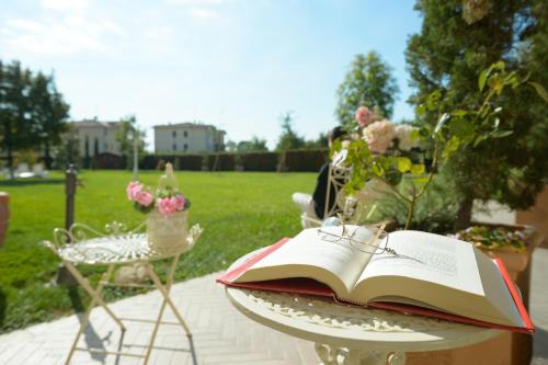 an open book sitting on a table in a garden at Boutique Hotel San Giovanni in San Giovanni in Persiceto