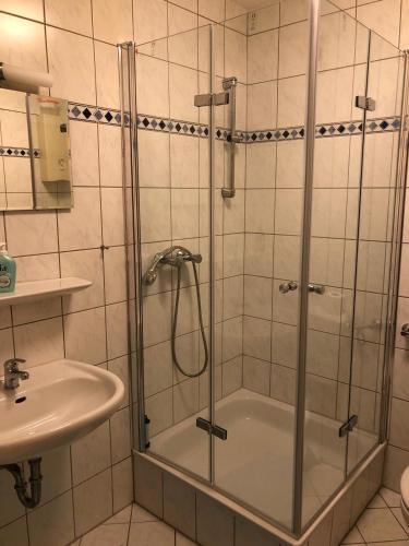 a shower with a glass door next to a sink at Apartment 28 o M in Castrop-Rauxel