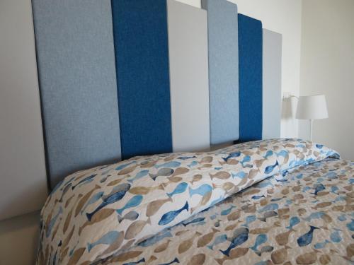 a bedroom with a bed with a blue and white headboard at Il Capanno in Pietra Ligure