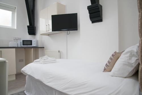 Tempat tidur dalam kamar di TLK Apartments & Hotel - Beckenham