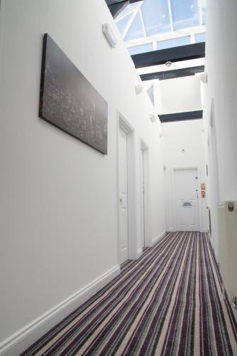 a hallway with white walls and a flat screen tv on the wall at TLK Apartments & Hotel - Beckenham in Beckenham