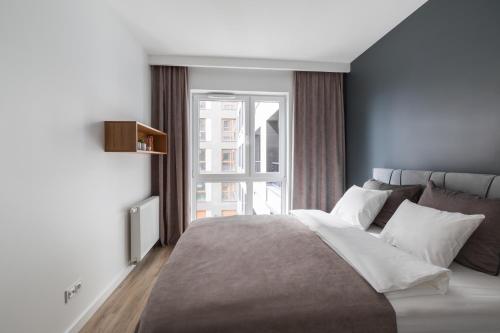 sypialnia z dużym łóżkiem i oknem w obiekcie Luksusowy apartament przy Targach w Poznaniu
