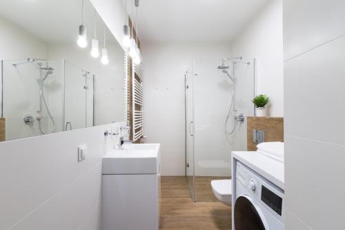 biała łazienka z umywalką i toaletą w obiekcie Luksusowy apartament przy Targach w Poznaniu