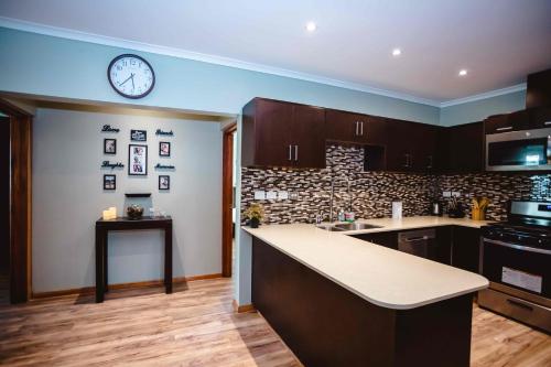 a kitchen with a counter and a clock on the wall at Platinum Cawa Apartments in Nadi
