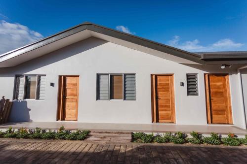 a white house with wooden shutters at Platinum Cawa Apartments in Nadi
