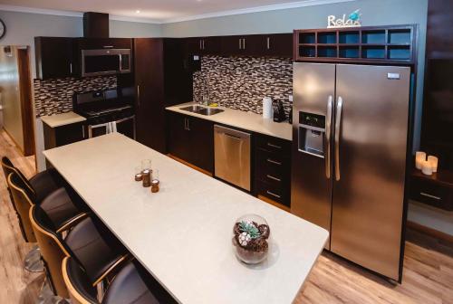 a kitchen with a refrigerator and a table and chairs at Platinum Cawa Apartments in Nadi