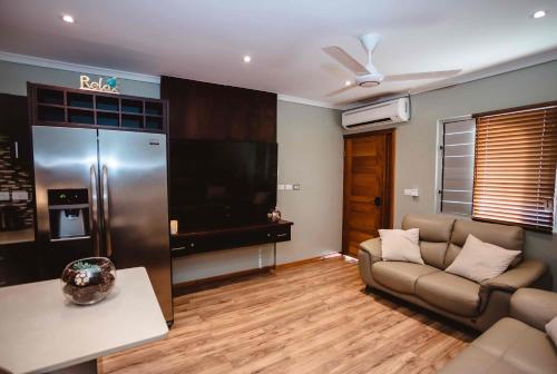 a living room with a couch and a large television at Platinum Cawa Apartments in Nadi