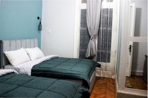 a bedroom with a bed and a window at Cheers Hostel Cairo in Cairo