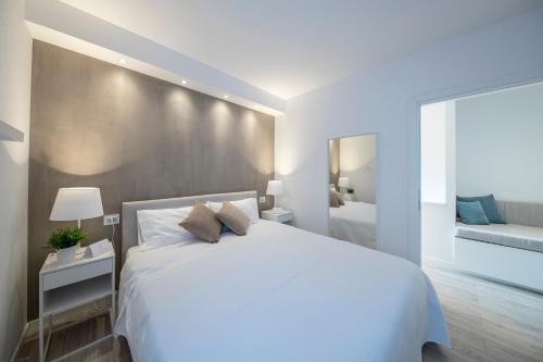a white bedroom with a large bed and a mirror at Italia Living Villa in Padenghe sul Garda