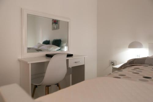 a bedroom with a desk and a bed and a mirror at Apartments Gacka Valley in Otočac