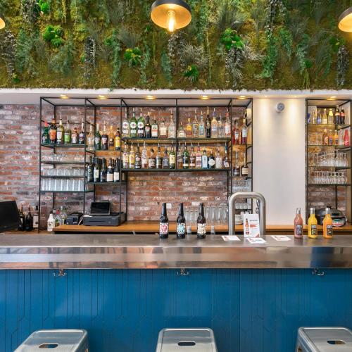 un bar dans un restaurant avec un mur de briques dans l'établissement Hotel The Playce by Happyculture, à Paris