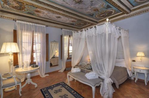 1 dormitorio con cama con dosel y techo artesonado en Rinascimento Bed & Breakfast, en Pisa