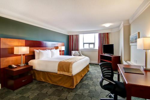 a hotel room with a bed and a desk at Edmonton Inn and Conference Centre in Edmonton