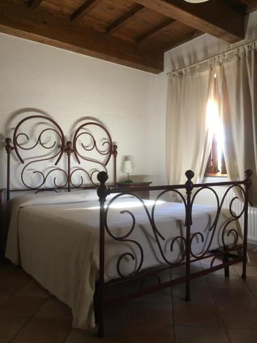 a bedroom with a bed with a white blanket and a window at Casale degli ulivi in Gualdo Tadino